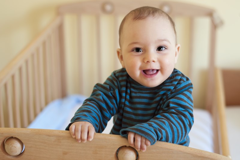 baby smiling in cot 