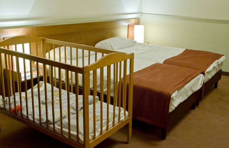 baby cot next to double bed